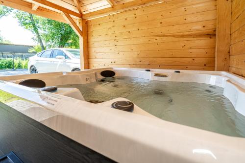 a jacuzzi tub in a wooden room with at Aparthome Tatra in Biały Dunajec