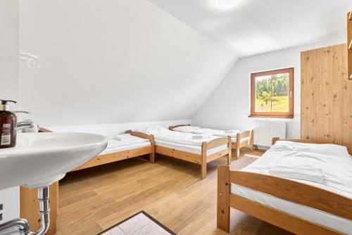 a bathroom with two beds and a sink and a tub at Lenhart's Ryžovna by Mountain ways in Boží Dar