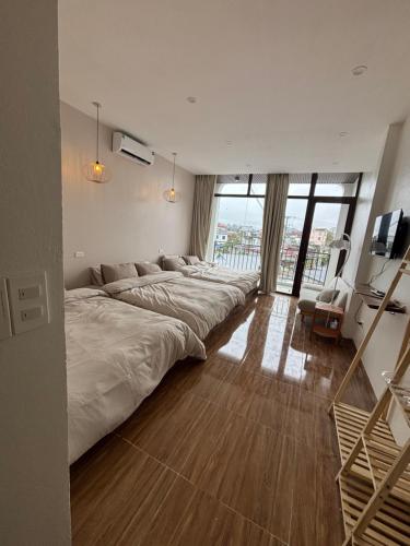 a large bedroom with a large bed with large windows at Lơ Mơ House in Làng Môn