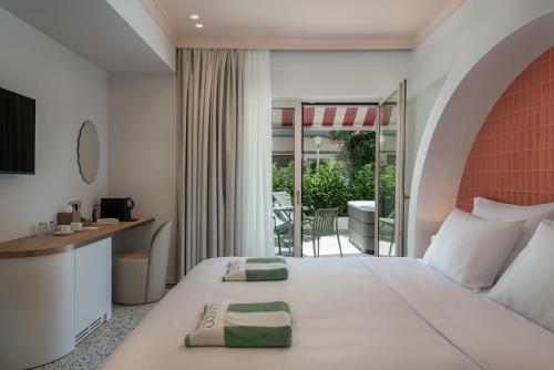 a hotel room with a bed and a desk and a balcony at Villa Coo Boutique Hotel - Adults Only in Kos
