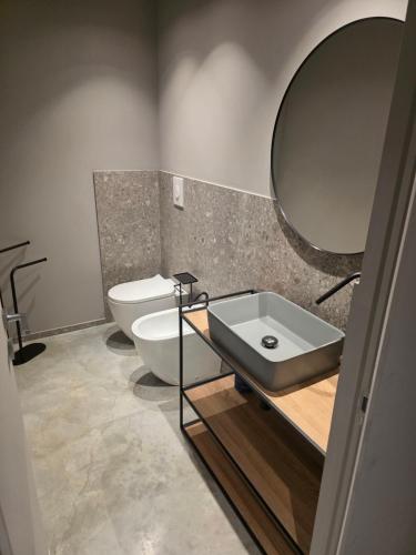 a bathroom with a sink and a toilet and a mirror at Sottocoperta in Roseto degli Abruzzi