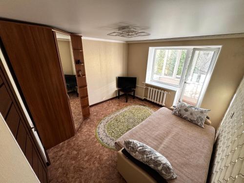 a bedroom with a bed and a window and a television at Квартира 2х ком на Амангельды 1 in Balqash