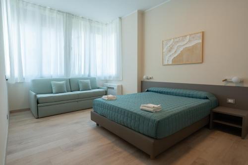a bedroom with a bed and a couch at Residence La Scogliera in Alassio