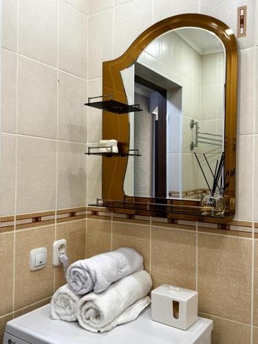 a bathroom with a mirror and towels on a sink at Квартира 2х ком на Амангельды 1 in Balqash