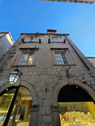 a stone building with two arches in front of it at Lausa Dubrovnik Rooms in Dubrovnik