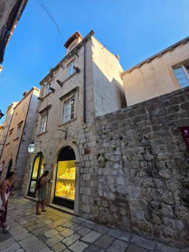 a brick building with people standing outside of it at Lausa Dubrovnik Rooms in Dubrovnik