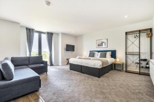 a bedroom with a bed and a couch at Cotswolds Apartment 1, sleeps 4 in Chipping Norton