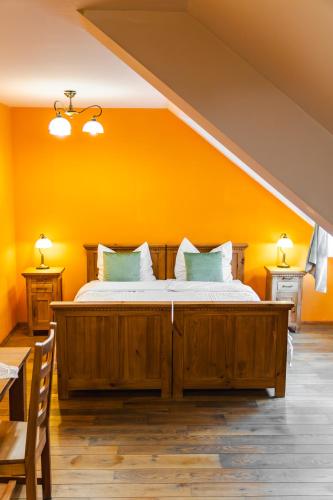 a bedroom with a large bed with yellow walls at Karczma Regionalna Hotel GOŚCINNA CHATA in Wysowa-Zdrój