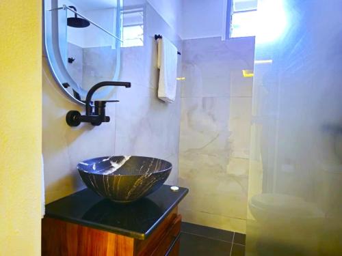a bathroom with a bowl sink and a mirror at Domaine Béthania in Tadiénou