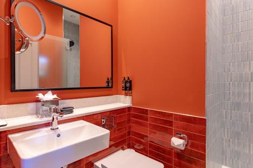 a bathroom with a white sink and a mirror at Ansty Hall in Coventry