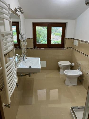 a bathroom with a toilet and a sink at Le Pavoncelle in Bosa