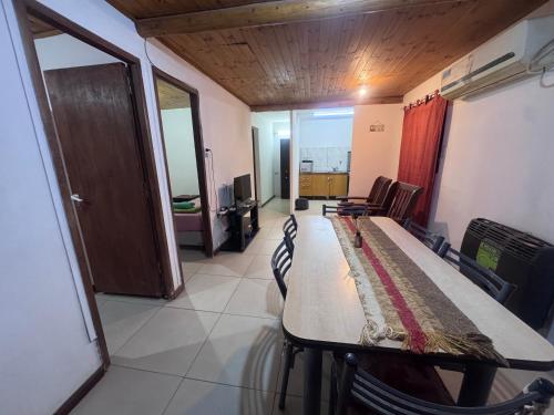 a room with a long table with chairs and a living room at René Favaloro in Rincon de los Sauces