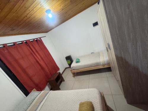 a small room with a red curtain and a bed at René Favaloro in Rincon de los Sauces