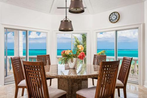 a dining room with a table and chairs and the ocean at Villa with Sea View in Providenciales