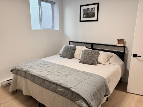 a bedroom with a bed with two pillows on it at Upscale One Bedroom Suite in New Build in Kelowna