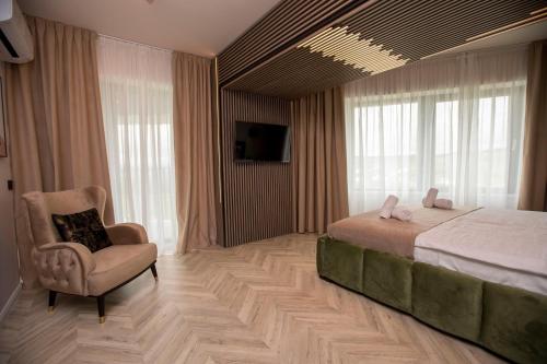a bedroom with a bed and a chair and window at Tower Apartments in Cluj-Napoca