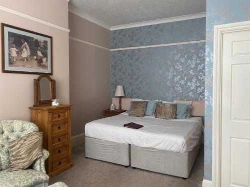 a bedroom with a bed and a chair at The Belmont in Shanklin