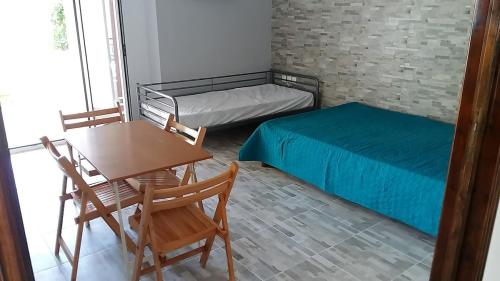 a small room with a bed and a table and a desk at Muretto House in Oreoi