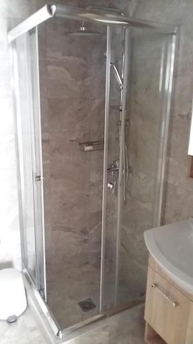 a shower with a glass door in a bathroom at Muretto House in Oreoi