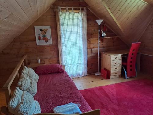 a bedroom with a bed and a desk in a attic at Holiday Home Geppetto in Gornji Velemerić