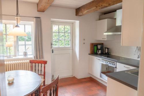a kitchen with a table and a dining room at Ferienwohnung Blücherkate II - Boldevitzer Rügenkaten in Parchtitz