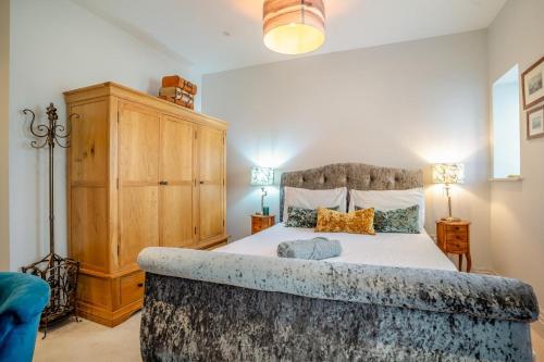 a bedroom with a large bed and a wooden cabinet at 2 Bed in Porthcawl oc-87294 in Porthcawl
