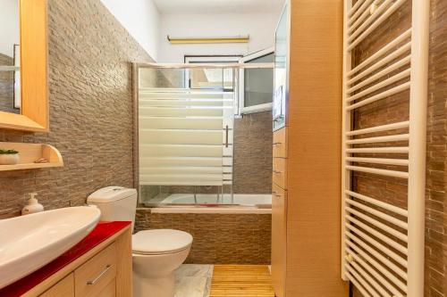a bathroom with a toilet and a sink and a tub at BIG BLUE in Rafina