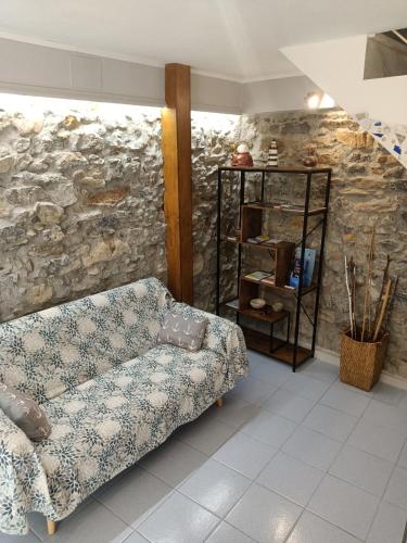 a living room with a couch and a stone wall at Casa Ida in Montemarcello