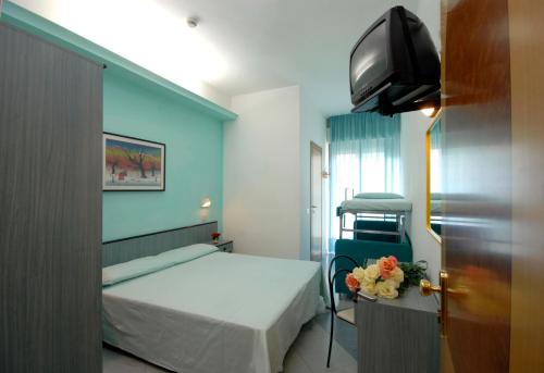 um quarto de hospital com uma cama e uma televisão em Hotel Christian em Rimini