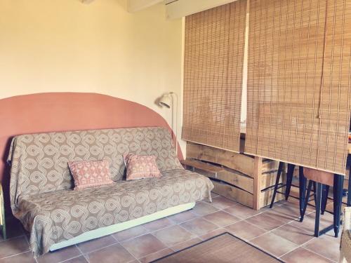 a couch with two pillows on it in a room at Espace Bulle-Zen in Burlats