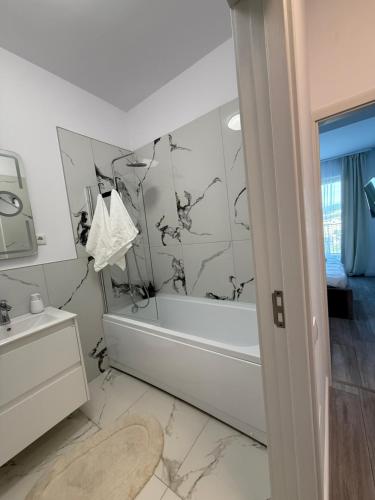 a bathroom with a tub and a sink at Urban Nest Florești in Floreşti