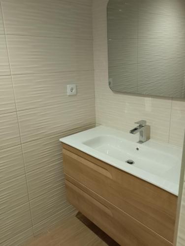 a bathroom with a sink and a mirror at Maresia BIKE ROOMS in São Félix da Marinha