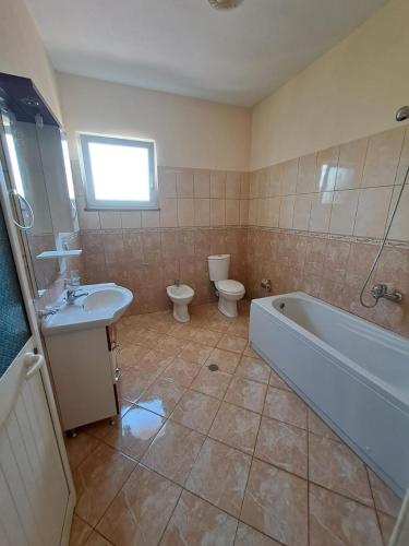 a bathroom with a tub and a toilet and a sink at Villa Elezi in Culaj