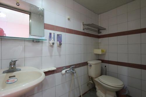 a bathroom with a toilet and a sink at Wu Li Ting B&B in Hengchun