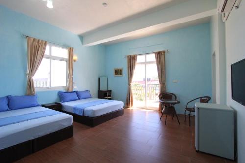 a hotel room with two beds and a television at Wu Li Ting B&B in Hengchun