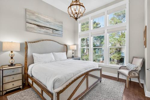 a bedroom with a bed and a chair and windows at Mystic Seas in Watersound Beach