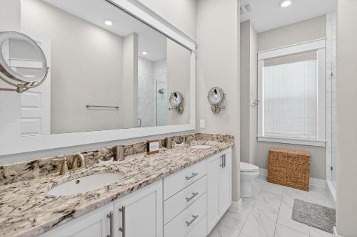 a white bathroom with a sink and a mirror at Mystic Seas in Watersound Beach
