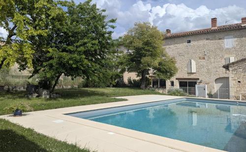 a swimming pool in a yard next to a building at Grande chambre avec piscine in Villeneuve-sur-Vère