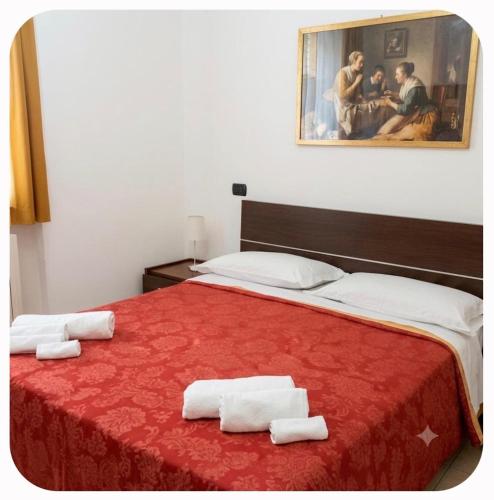 a bedroom with a red bed with towels on it at Casa Panorama in Monte di Procida