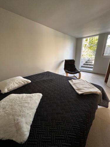 a bedroom with a bed with two pillows and a chair at SeaviewHouse Rudkøbing in Rudkøbing