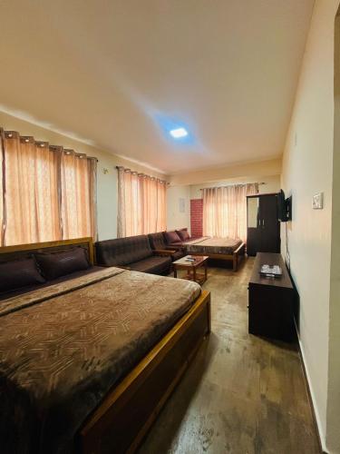a hotel room with a bed and a couch at Green Hills Cottage in Aravankādu