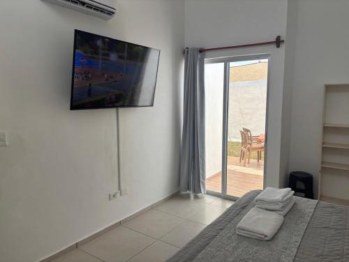a bedroom with a bed and a tv on the wall at In Wotoch in Cancún