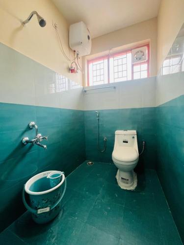 a bathroom with a toilet and a sink at Green Hills Cottage in Aravankādu