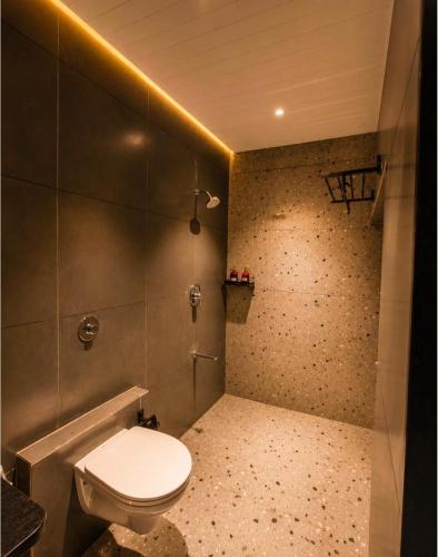 a bathroom with a white toilet in a room at The Peach Boho in Mount Ābu
