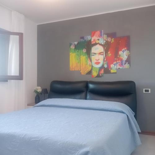 a bedroom with a bed with a painting on the wall at Bilocale sul Trasimeno in San Feliciano