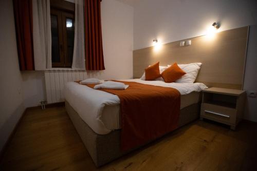 a bedroom with a large bed with an orange blanket at Orange stan in Žabljak