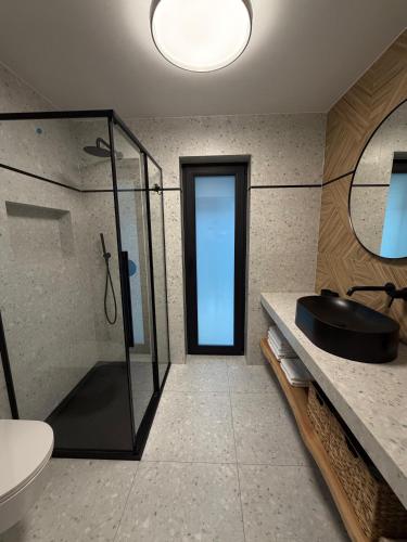 a bathroom with a glass shower and a sink at Stodoły Północ in Debina