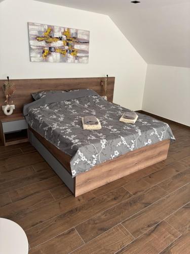 a bed in a bedroom with a wooden floor at Zelena reka 4 in Vrhpolje