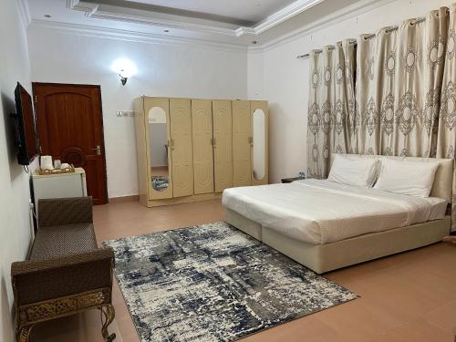 a bedroom with a bed and a chair in it at Simple Beach Stay 100m to Dahariz Beach Salalah in Salalah