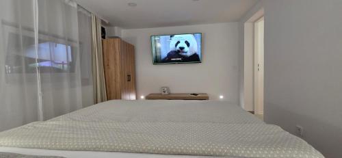 a bedroom with a bed with a tv on the wall at Melody Apartment Kutina in Kutina